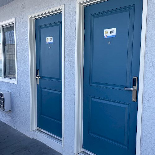 Two blue doors with room numbers 